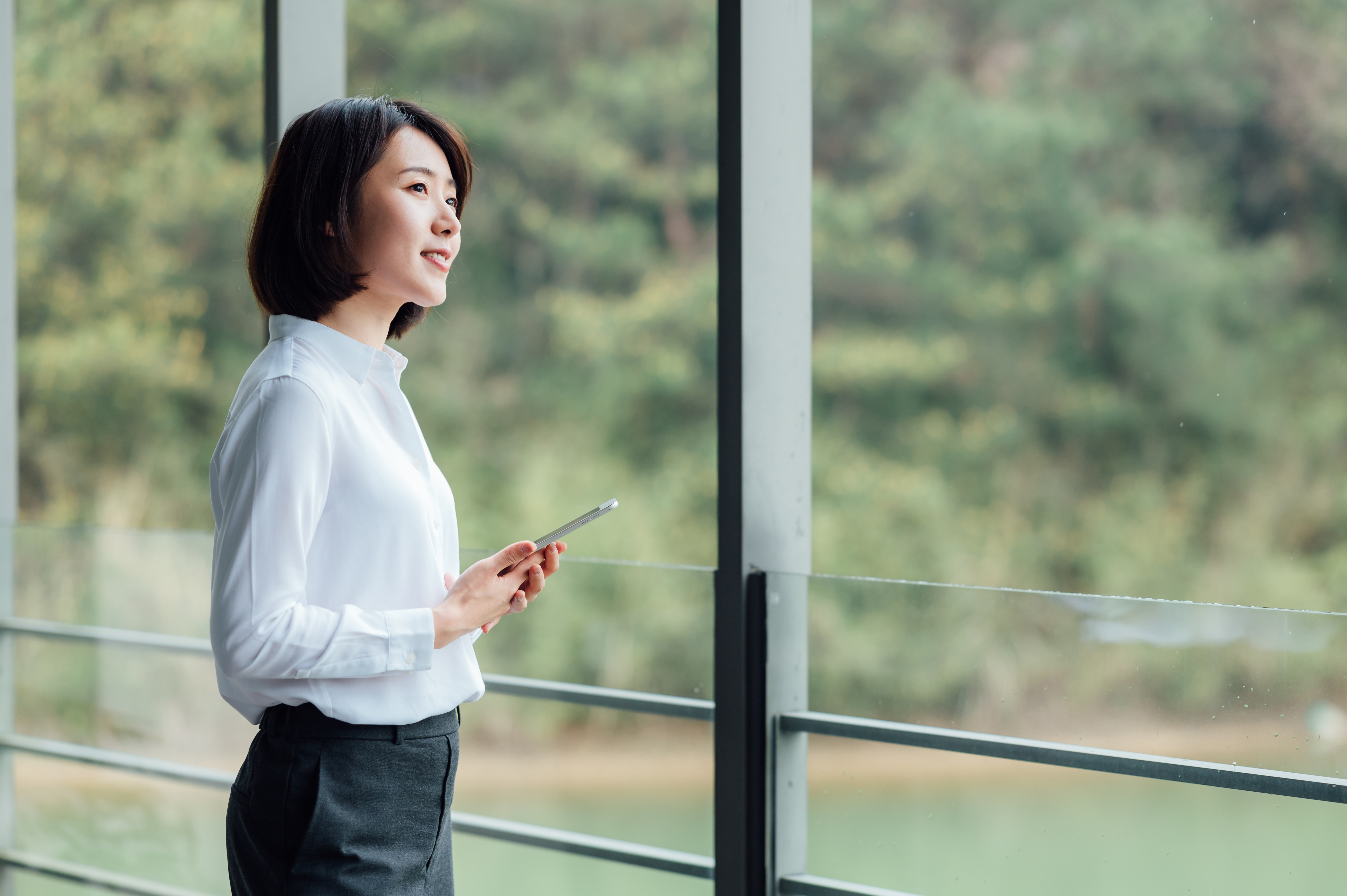 asian-businesswoman-using-ipad-at-office-window-2021-08-28-14-47-33-utc